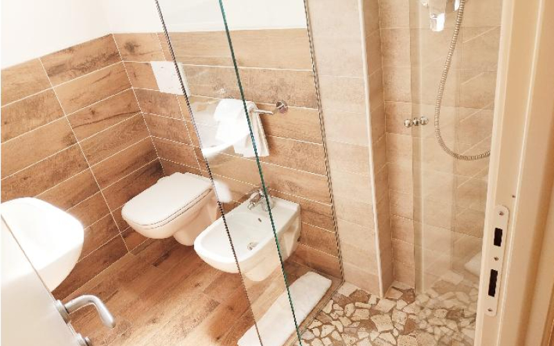Modernes, warmes Bad mit Holzfliesen und eleganter Dusche.